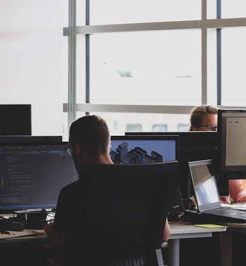 people sitting on chair in front of computer monitor